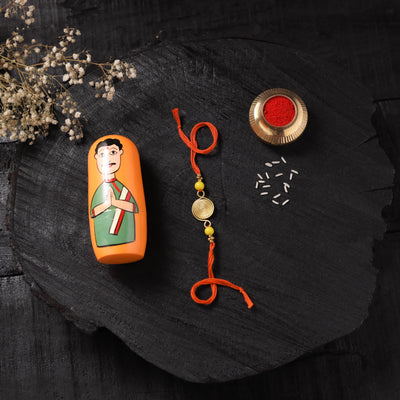 Orange - Handcrafted Tribal Dokra Brass Thread Rakhi with Banaras Wood Doll Box 12