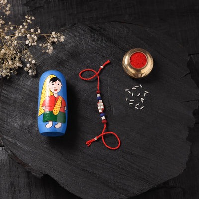 Red - Handcrafted Tribal Dokra Brass Thread Rakhi with Banaras Wood Doll Box 40