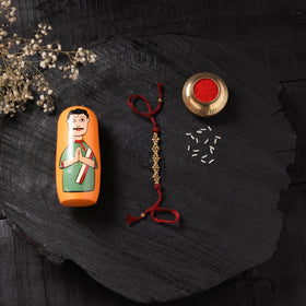 Red - Handcrafted Tribal Dokra Brass Thread Rakhi with Banaras Wood Doll Box 45