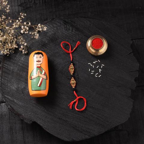 Red - Handcrafted Tribal Dokra Brass Thread Rakhi with Banaras Wood Doll Box 46