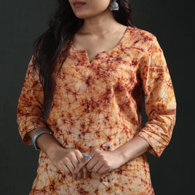 Notched round neck and sleeve of the cream batik kurta, the rust and maroon lines close in