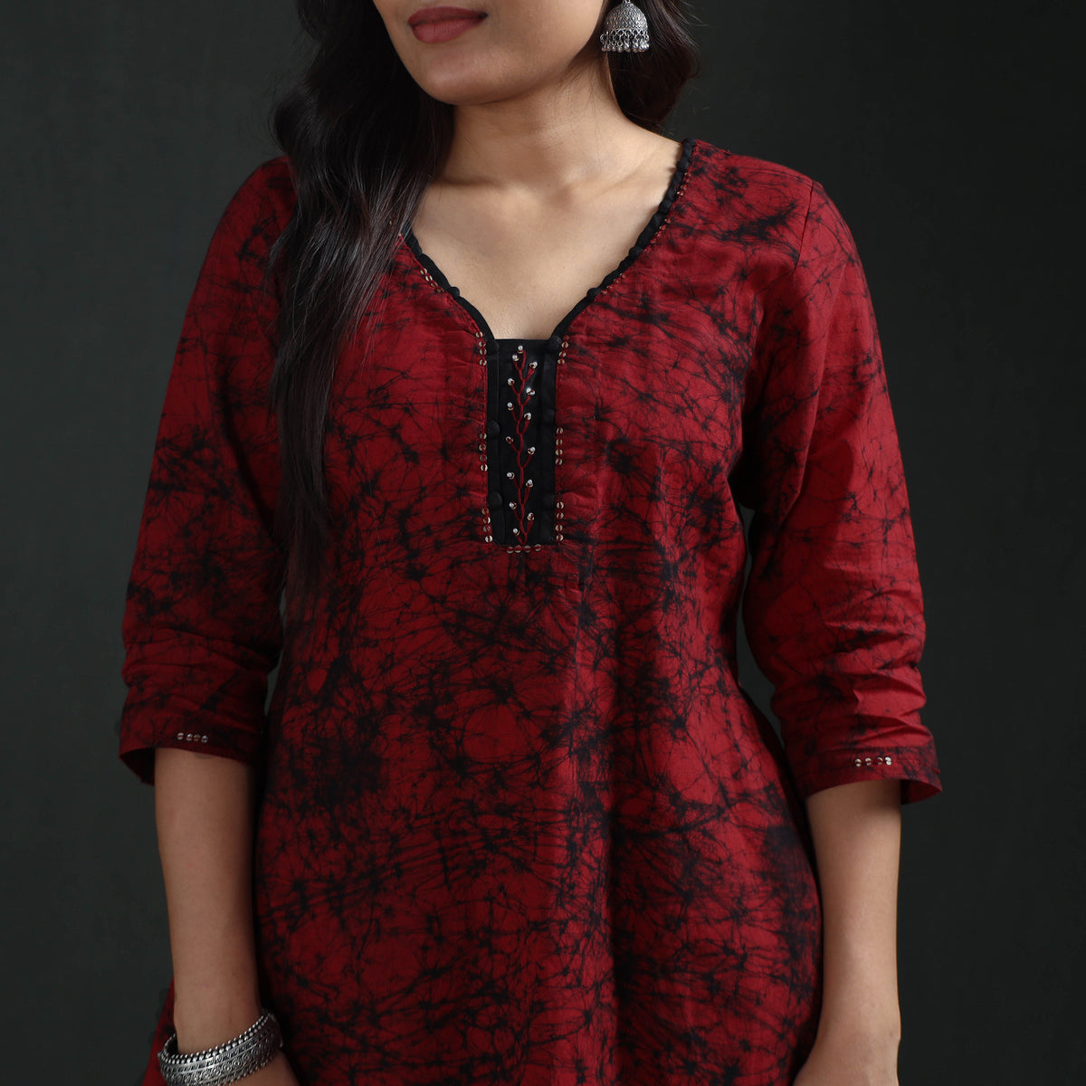 Black neck panel and beaded placket on the maroon Batik kurta, worn