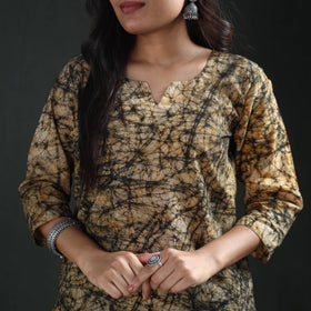 Notched round neck and sleeve of the beige batik kurta, close, black and ochre web