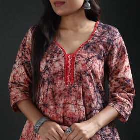 Red neck panel with white leaf-vine embroidery on the cream batik kurta