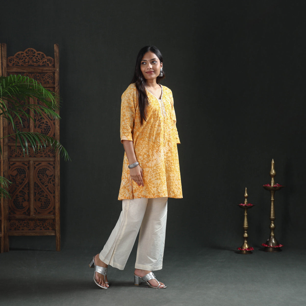Front view of the yellow batik kurta at mid-thigh, styled for casual wear