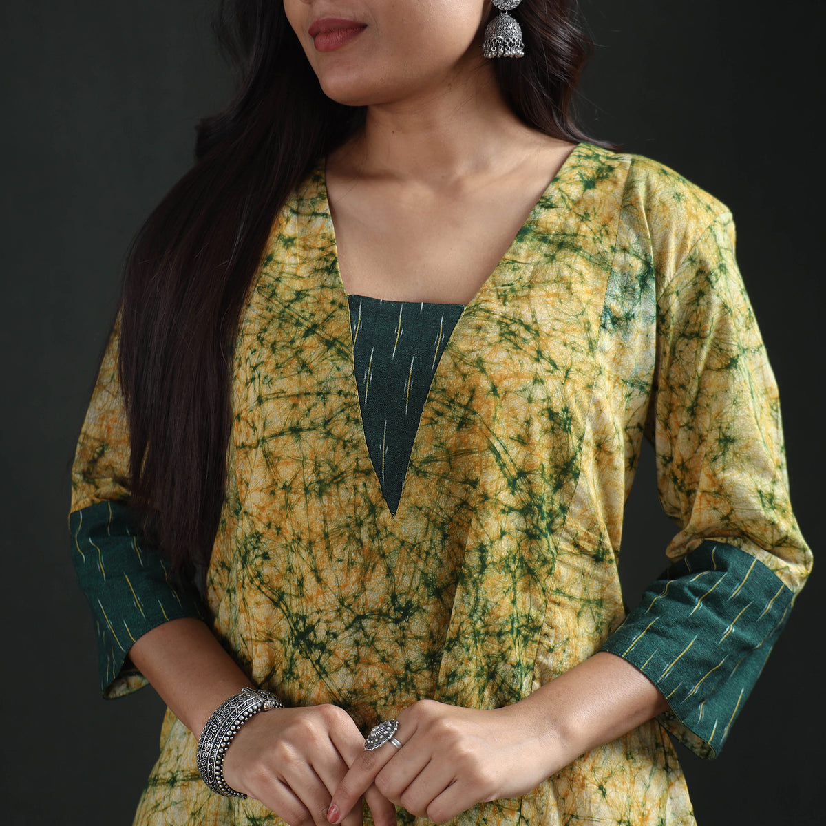 Deep V neckline of the yellow batik kurta with its dark green square inset and cuff