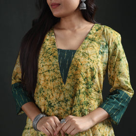 Deep V neckline of the yellow batik kurta with its dark green square inset and cuff