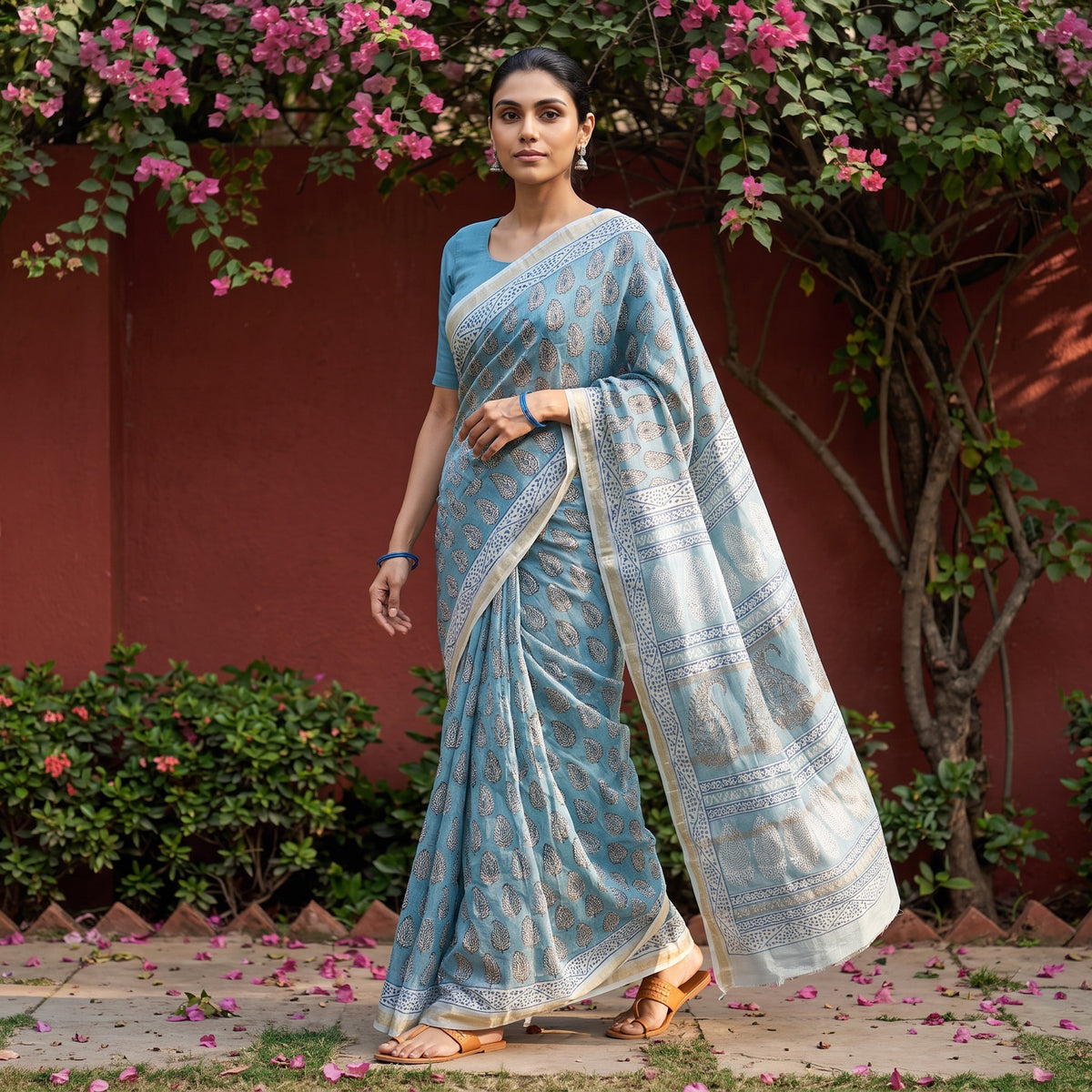Blue Bagh Hand Block Print Natural Dyed Maheshwari Silk Zari Border Saree, worn by a woman walking in a garden courtyard, AI visual of the saree, iTokri