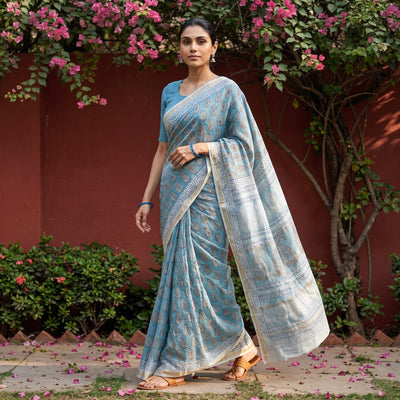 Blue Bagh Hand Block Print Natural Dyed Maheshwari Silk Zari Border Saree, worn by a woman walking in a garden courtyard, AI visual of the saree, iTokri