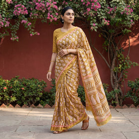 Brown Bagh Hand Block Print Natural Dyed Maheshwari Silk Zari Border Saree, worn by a woman walking in a garden courtyard, AI visual of the saree, iTokri