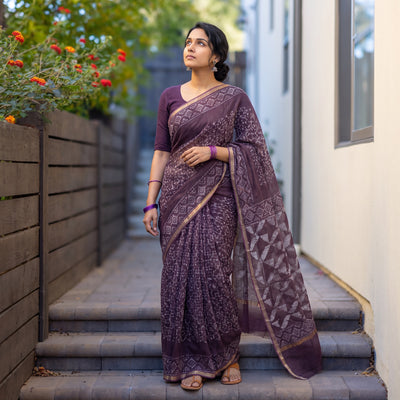 Purple Batik Hand Block Print Kota Doria Cotton Saree, worn by a woman on garden steps beside a white wall, AI visual of the saree, iTokri