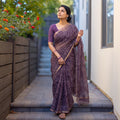 Purple Batik Hand Block Print Kota Doria Cotton Saree, worn by a woman on garden steps beside a white wall, AI visual of the saree, iTokri