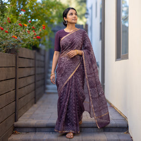 Purple Batik Hand Block Print Kota Doria Cotton Saree, worn by a woman on garden steps beside a white wall, AI visual of the saree, iTokri