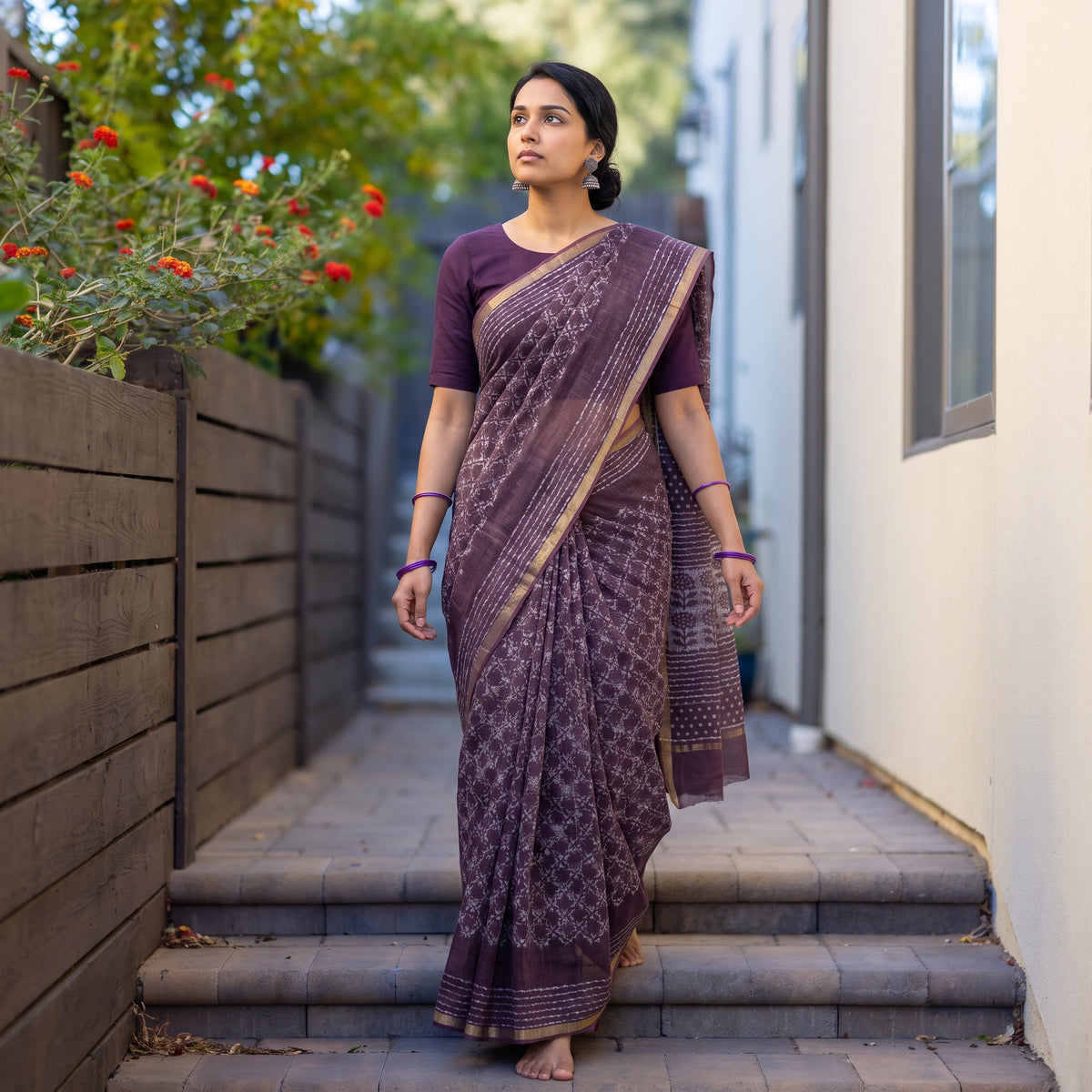 Purple Batik Hand Block Print Kota Doria Cotton Saree, worn by a woman on garden steps beside a white wall, AI visual of the saree, iTokri