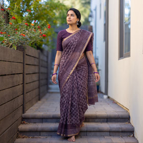 Purple Batik Hand Block Print Kota Doria Cotton Saree, worn by a woman on garden steps beside a white wall, AI visual of the saree, iTokri