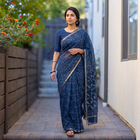 Navy Blue Batik Hand Block Print Kota Doria Cotton Saree, worn by a woman on garden steps beside a white wall, AI visual of the saree, iTokri