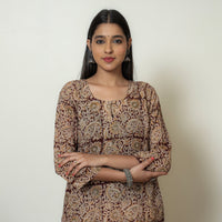 Front half-length view of a beige Kalamkari block print cotton kurta, model with arms crossed