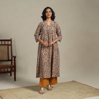 Front full-length view of a beige Kalamkari block print cotton kurta with black vines, on a model