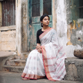 White Bengal Ikat Handwoven Pure Cotton Zari Border Saree for Durga Puja, draped and worn by a woman, AI visual of the saree, iTokri