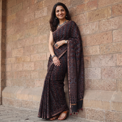 Black Ajrakh hand block print natural dyed Kota Doria cotton saree, draped and worn by a woman, AI visual of the saree, iTokri