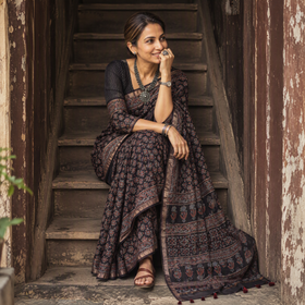 Black Ajrakh hand block print natural dyed Kota Doria cotton saree, draped and worn by a woman, AI visual of the saree, iTokri