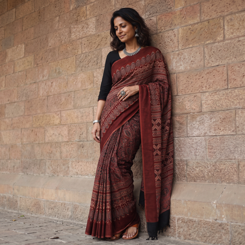 Maroon Ajrakh hand block print natural dyed handloom Maheshwari cotton saree with tassels, draped and worn by a woman, AI visual of the saree, iTokri