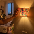 Handpainted Tholu Bommalata Leather Wall Lamp (Small), lit in a home in the evening, AI visual of the light, iTokri