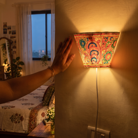Handpainted Tholu Bommalata Leather Wall Lamp (Small), lit in a home in the evening, AI visual of the light, iTokri