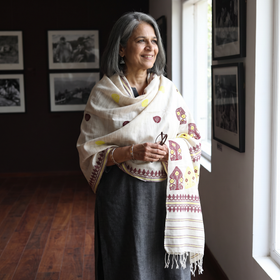White Handspun Handwoven Pure Eri Silk Aari Hand Embroidered Shawl of Assam, worn by a model, AI visual of the shawl, iTokri