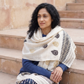 White Handspun Handwoven Pure Eri Silk Aari Hand Embroidered Shawl of Assam, worn by a model, AI visual of the shawl, iTokri