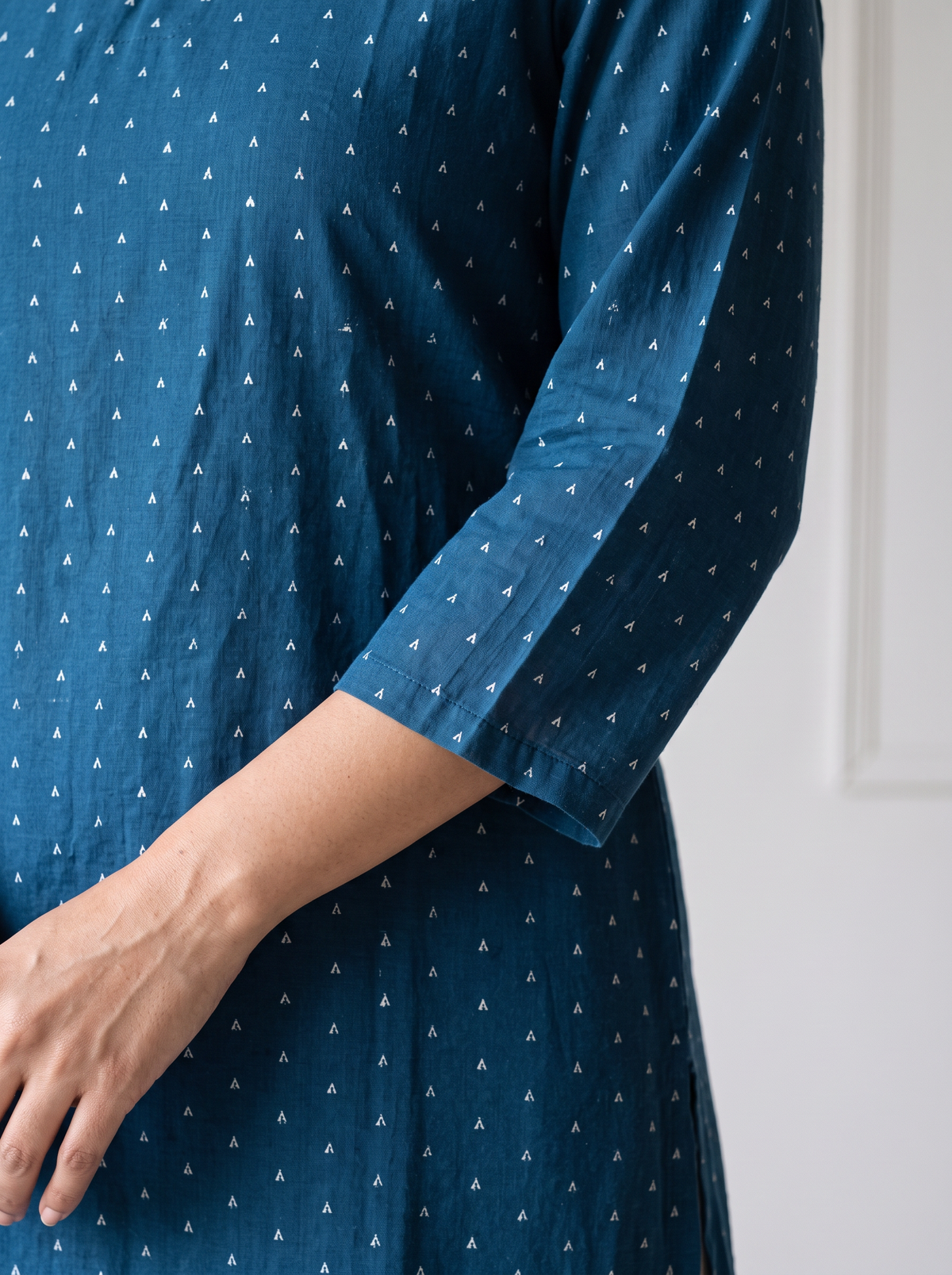 Blue Jacquard Cotton Arrowhead Dots Kurta, sleeve close-up, 3/4 sleeves, plain cuffs, slits to the hip, AI visual of the kurta, iTokri
