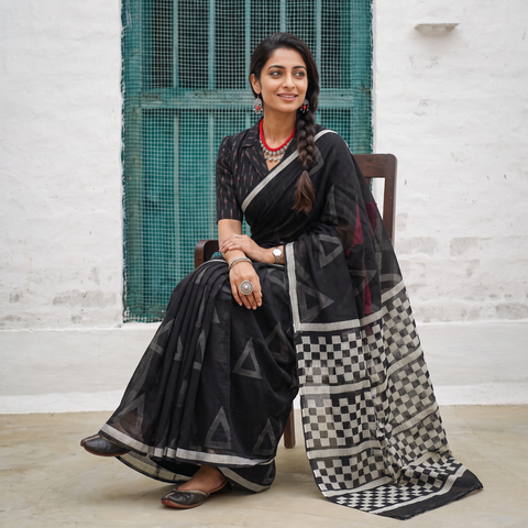 Black Sanganeri hand block print Kota Doria cotton saree with bold geometric motifs, draped and worn by a woman, AI visual of the saree, iTokri