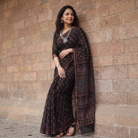 Black Kutch Ajrakh hand block print natural dyed Kota Doria cotton saree, draped and worn by a woman, AI visual of the saree, iTokri