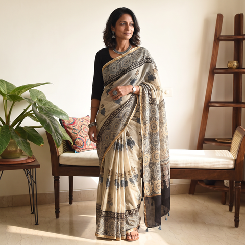 Beige and black Kutch Ajrakh hand block print natural dyed Kota Doria cotton saree, draped and worn by a woman, AI visual of the saree, iTokri