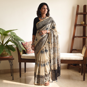 Beige and black Kutch Ajrakh hand block print natural dyed Kota Doria cotton saree, draped and worn by a woman, AI visual of the saree, iTokri