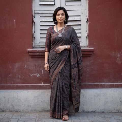 Black Kutch Ajrakh hand block print natural dyed Kota Doria cotton saree, draped and worn by a woman, AI visual of the saree, iTokri