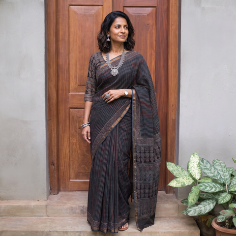 Black Kutch Ajrakh hand block print natural dyed Kota Doria cotton saree, draped and worn by a woman, AI visual of the saree, iTokri