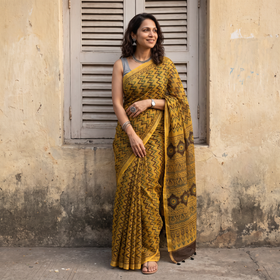 Mustard yellow Kutch Ajrakh hand block print natural dyed Kota Doria cotton saree, draped and worn by a woman, AI visual of the saree, iTokri