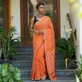 Orange Kutch Bandhani tie-dye cotton saree, draped and worn by a woman, AI visual of the saree, iTokri