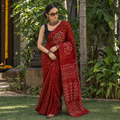 Red Kutch Bandhani tie-dye cotton saree, draped and worn by a woman, AI visual of the saree, iTokri