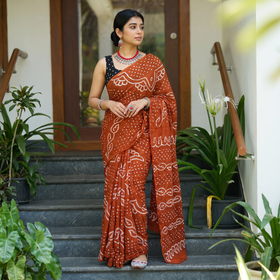 Orange Kutch Bandhani tie-dye cotton saree, draped and worn by a woman, AI visual of the saree, iTokri