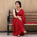 Red Kutch Bandhani tie-dye cotton saree, draped and worn by a woman, AI visual of the saree, iTokri