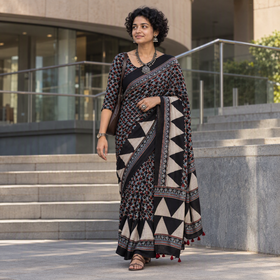Black Kutch Hand Block Print Natural Dyed Pure Mul Cotton Ajrakh Saree with Tassels, draped and worn by a woman, AI visual of the saree, iTokri
