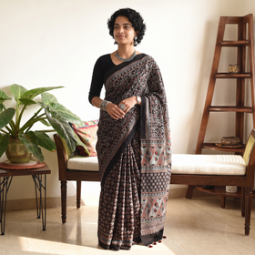 Black Kutch Hand Block Print Natural Dyed Pure Mul Cotton Ajrakh Saree with Tassels, draped and worn by a woman, AI visual of the saree, iTokri