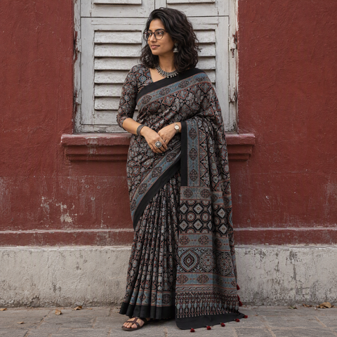 Black Kutch Hand Block Print Natural Dyed Pure Mul Cotton Ajrakh Saree with Tassels, draped and worn by a woman, AI visual of the saree, iTokri