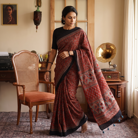 Red Kutch Hand Block Print Natural Dyed Pure Mul Cotton Ajrakh Saree with Tassels, draped and worn by a woman, AI visual of the saree, iTokri