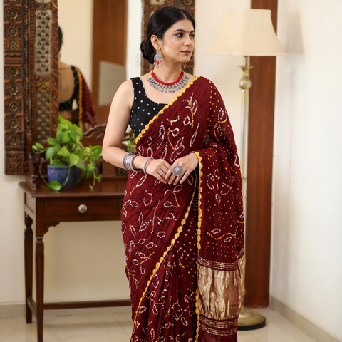 Maroon Kutch tie-dye Modal silk Bandhani saree with zari border, draped and worn by a woman, AI visual of the saree, iTokri