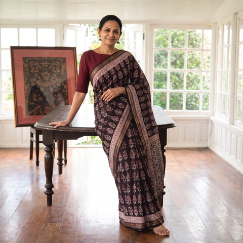 Black Maheshwari Silk Natural Dyed Bagh Hand Block Print Saree with Zari Border, draped and worn by a woman, AI visual of the saree, iTokri