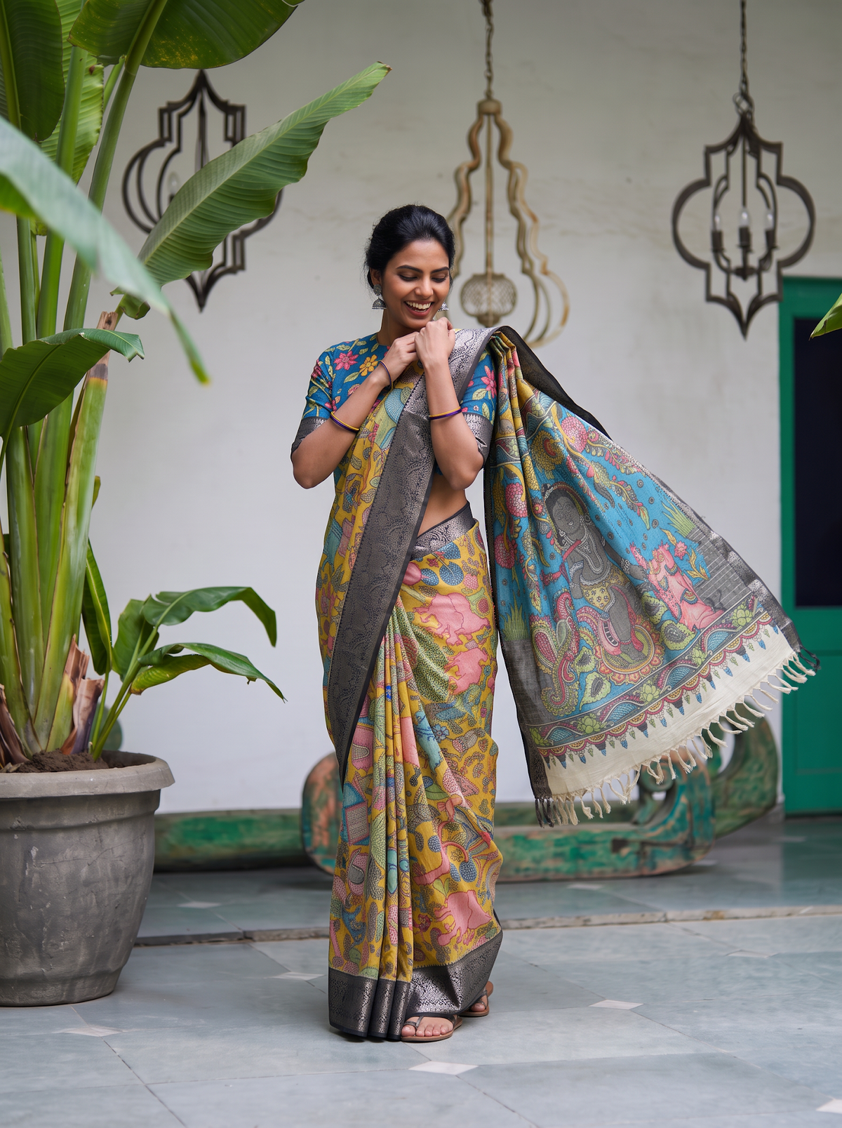 Teal figure pallu of the yellow Kalamkari saree held out, with cream tassels, AI visual of the saree, iTokri