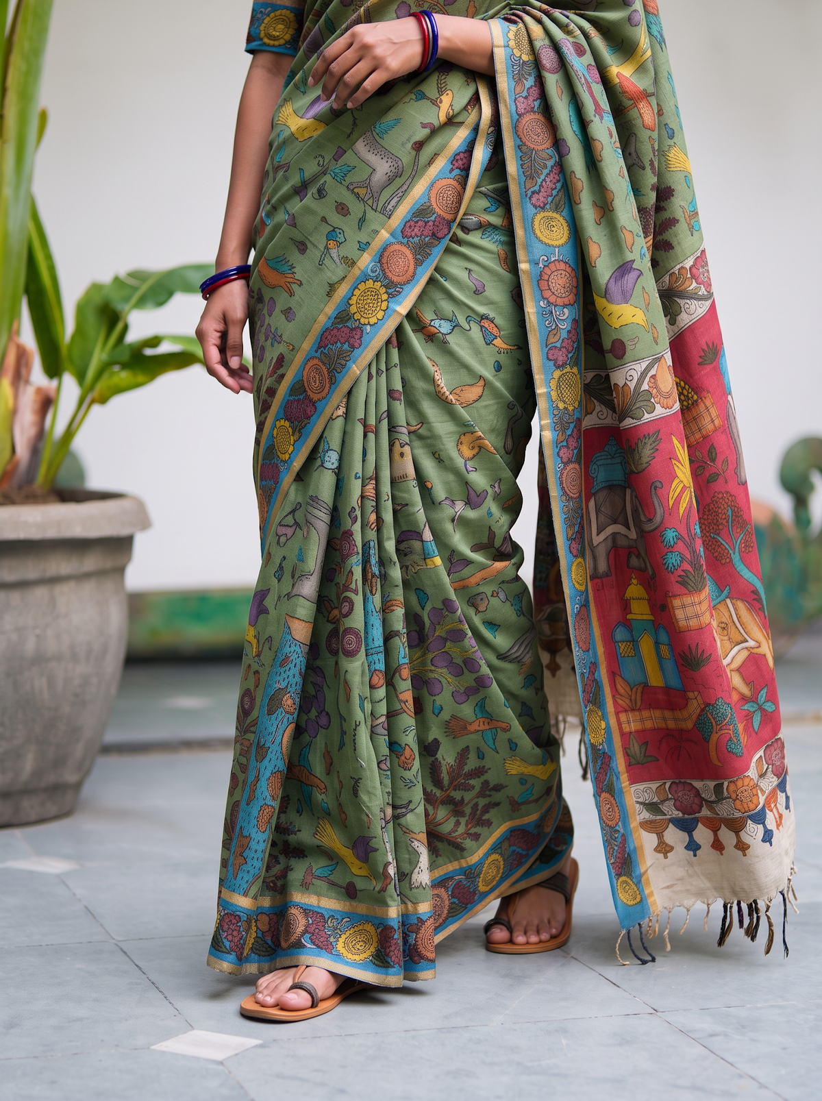 Pleats of the sage green body with painted animals over a sky blue hem, AI visual of the saree, iTokri
